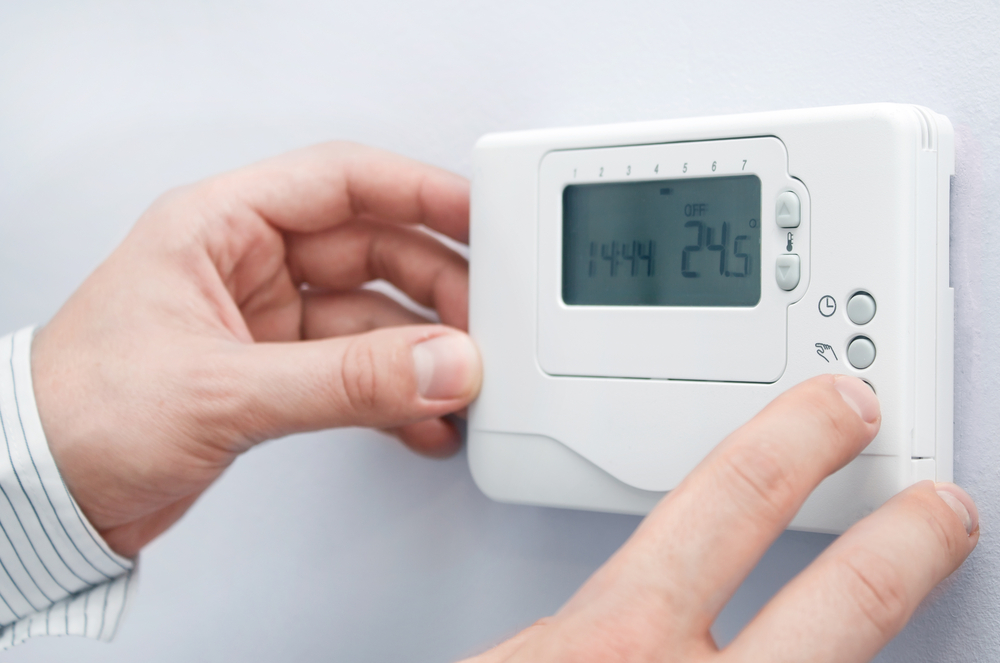 thermostat at home adjusting furnace operation